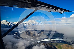 Aerial view of Mount Denali - mt Mckinley peak from a plane with glaciers around and blue sky above. Denali National