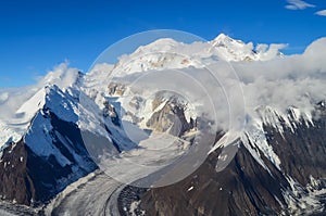 Aerial view of Mount Denali - mt Mckinley peak from a plane with glaciers around and blue sky above. Denali National