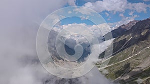 Aerial view of a mountain gorge with swirling clouds and mountain scenery