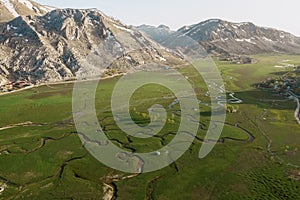 Aerial view of mountain meeting meadow with many paths