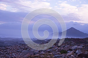 Aerial view of mountain in the morning. Mountains in fog and clouds with stones and rocks foreground.