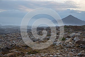 Aerial view of mountain in the morning. Mountains in fog and clouds with stones and rocks foreground.