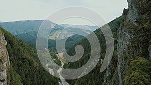 Aerial view of a mountain road in a beautiful deep gorge. Cars move on a mountain road.