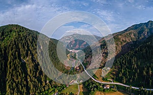 Aerial view of mountain road, mountains and a river near the town of Predazzo, Trentino, Italy consequences of bad weather,