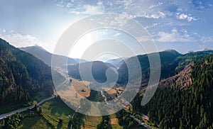 Aerial view of mountain road, mountains and a river near the town of Predazzo, Trentino, Italy consequences of bad weather,