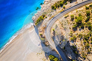 Aerial view of mountain road near blue sea with sandy beach