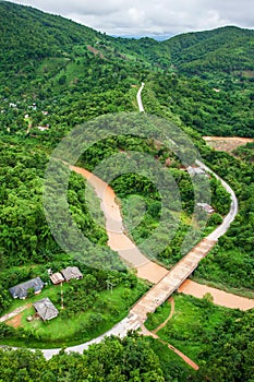 Aerial view of mountain road and river in rainy season