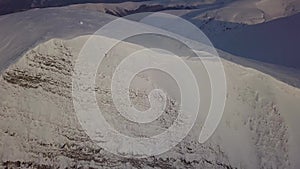 Aerial view of mountain snow-capped peak, at sunrise