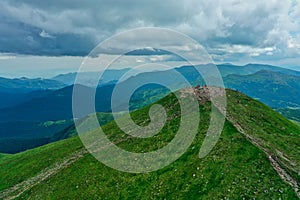 Aerial view of the mountain top with many young hikers against the backdrop of a mountain landscape.