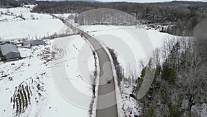 Aerial view of mountain twisted road in the winter and driving car. Snowy white winter and snow forest.