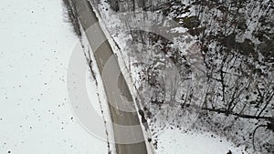 Aerial view of mountain twisted road in the winter and driving car. Snowy white winter and snow forest.