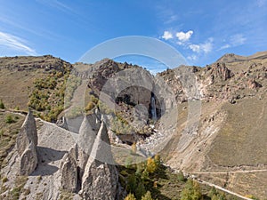 Aerial view of the mountain waterfall, Elbrus. Sharp peaks on the mountain are visible. Stormy river flows down from the