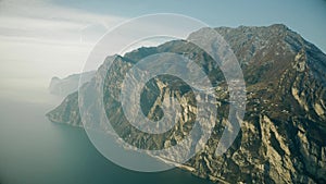 Aerial view of mountainous shore of the Lake Garda on a hazy day, Italy