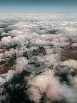 Aerial view on the mountains from the airplane window. Cloudy day. Background picture.