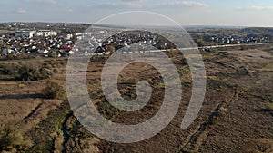 Aerial view of Movement of the train with freight cars. The train rides on the background of the village.