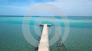 Aerial view. Moving forward on pier. Boardwalk in ocean.