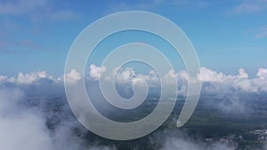 Aerial view of moving white clouds. The drone is flying high through the white cumulus clouds in the blue sky.
