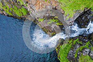 Aerial view of Mulafossur waterfall in Gasadalur village in Faroe Islands, North Atlantic Ocean. Photo made by drone from above.