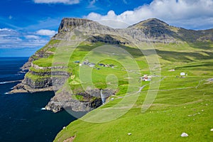 Aerial view of Mulafossur waterfall in Gasadalur village in Faroe Islands, North Atlantic Ocean. Photo made by drone from above.