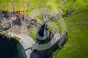 Aerial view of Mulafossur waterfall in Gasadalur village in Faroe Islands, North Atlantic Ocean. Photo made by drone from above.