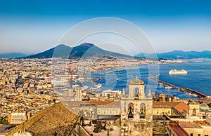 Malebný obrázek-pohlednice výhledem na město Neapol (Napoli) s slavný Vesuvem v pozadí, zlaté večerní světlo při západu slunce, Kampánie, Itálie.
