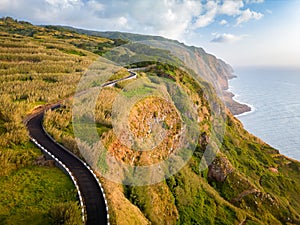 Aerial view of a narrow coastal road during the sunset. Winding path in the western part of the Madeira Island, Portugal, Europe