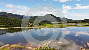 Aerial view of natural scenery green forest with mountains and river, blue sky background