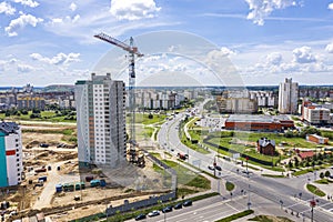 Aerial view of new apartment building under construction with crane on blue sky background