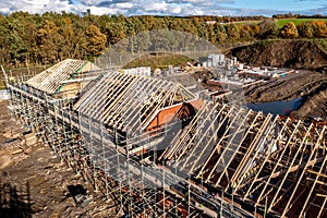 Aerial view of new build homes on a building site with exposed roof