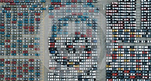 Aerial view of new cars stock at factory parking lot. Above view cars parked in a row. Automotive industry. Logistics business.