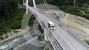 Aerial view of new concrete bridge with highway and driving white truck, transportation of goods concept. Stock footage
