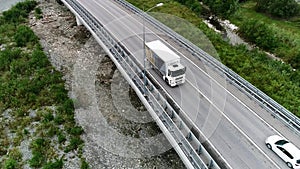 Aerial view of new concrete bridge with highway and driving white truck, transportation of goods concept. Stock footage