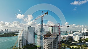 Aerial view of new developing residense in american urban area. Tower cranes at industrial construction site in Miami