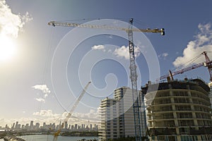 Aerial view of new developing residense in american urban area. Tower cranes at industrial construction site in Miami