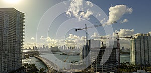 Aerial view of new developing residense in american urban area. Tower cranes at industrial construction site in Miami