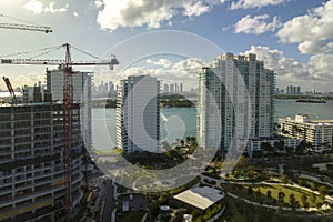 Aerial view of new developing residense in american urban area. Tower cranes at industrial construction site in Miami