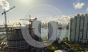 Aerial view of new developing residense in american urban area. Tower cranes at industrial construction site in Miami