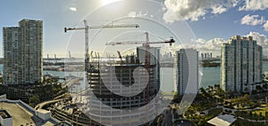 Aerial view of new developing residense in american urban area. Tower cranes at industrial construction site in Miami