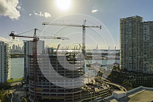 Aerial view of new developing residense in american urban area. Tower cranes at industrial construction site in Miami photo
