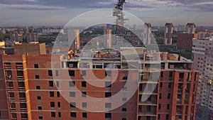 Aerial view of a new modern house under construction with a blue tower crane, red lantern at the end of the crane, building materi