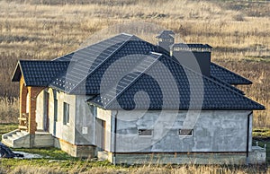 Aerial view of a new modern residential house under construction. Real estate development concept. Private home with metal roofing