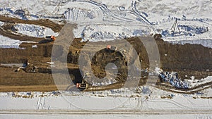 Aerial view of a new road construction site, construction of a new road in spring with snow