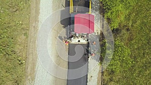 Aerial view of new road construction with workers and asphalt laying machinery at work