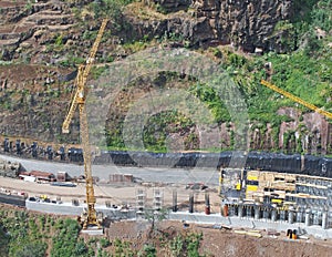 aerial view of a new road under construction with crane and construction materials and machinery working on the site being