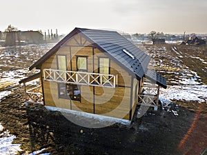 Aerial view of new wooden ecological traditional house cottage of natural lumber materials with steep shingle roof under