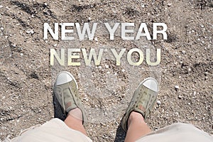 Aerial view of New year New you word on sand with people foot wear canvas shoe standing.goal resolutions for life