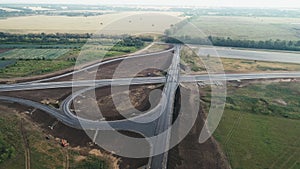 Aerial view of the newly built traffic intersection. Transport interchange of highways. A road under construction in the