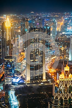 Aerial View Of Night Dubai Cityscape Skyline. Street Night Traffic Of Illuminated Cityscape With Skyscraper And Towers