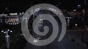 Aerial view of night traffic on the wide road along the big city street. Stock footage. Beautiful avenue at night with