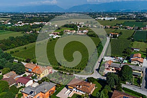 Aerial view of Northern Italy countryside in region with small towns, vineyards and cultivated fields and farmlands